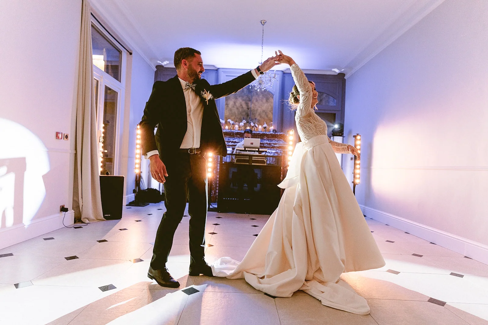 Le marié fait tourner la mariée sous son bras pendant leur première danse.