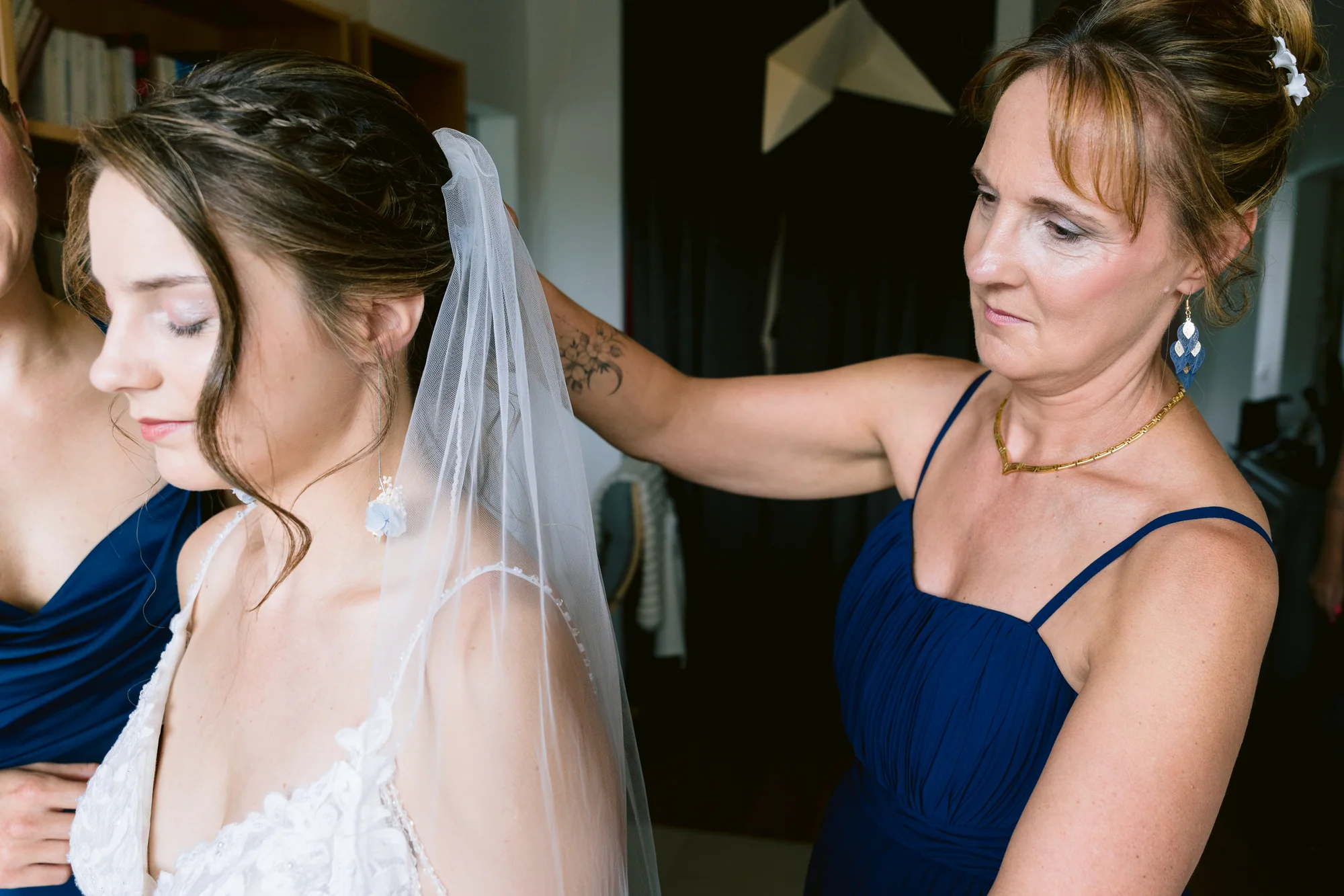 Un proche ajuste le voile de la mariée