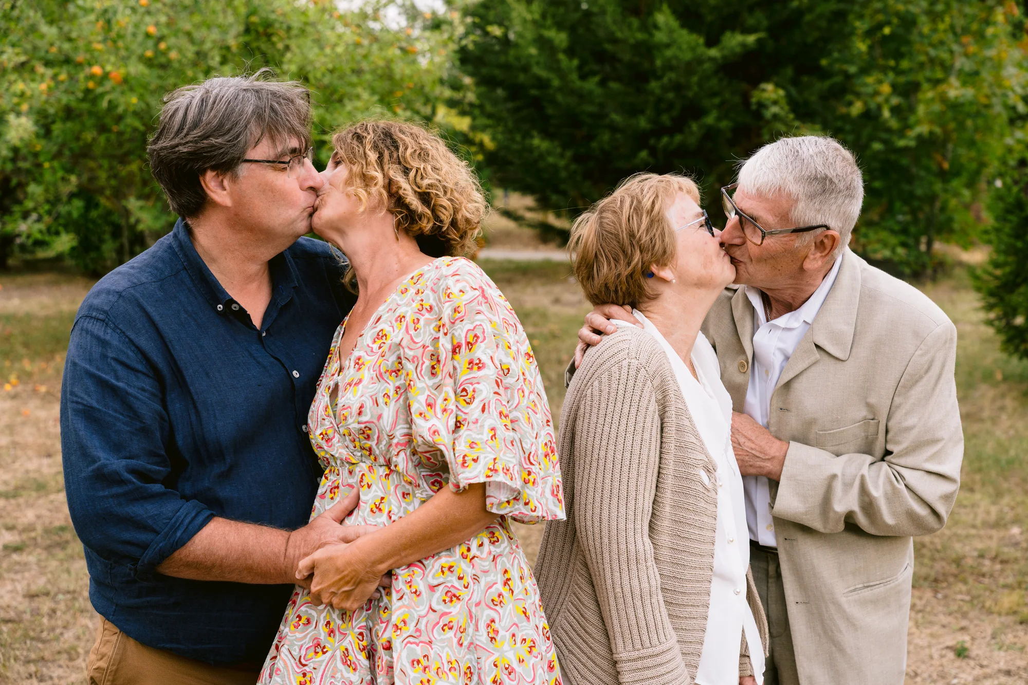 Deux couples de proches échangent un baiser