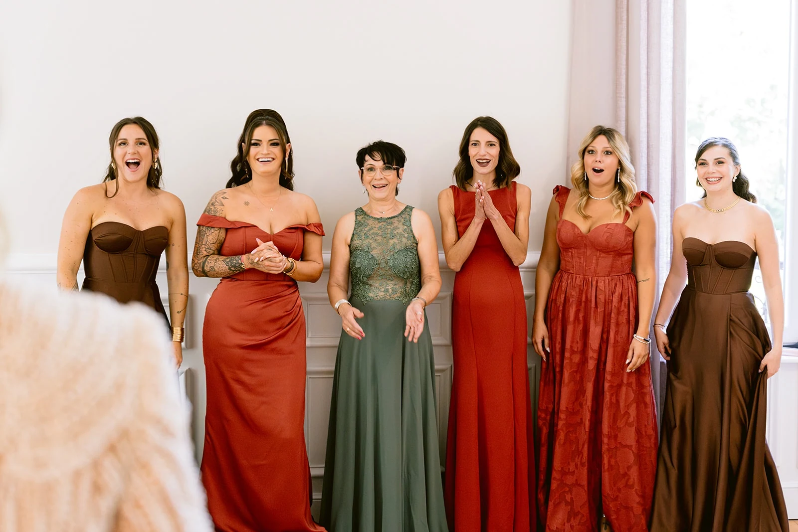 Les proches de la mariée découvrent sa tenue avec des sourires et des regards surpris.