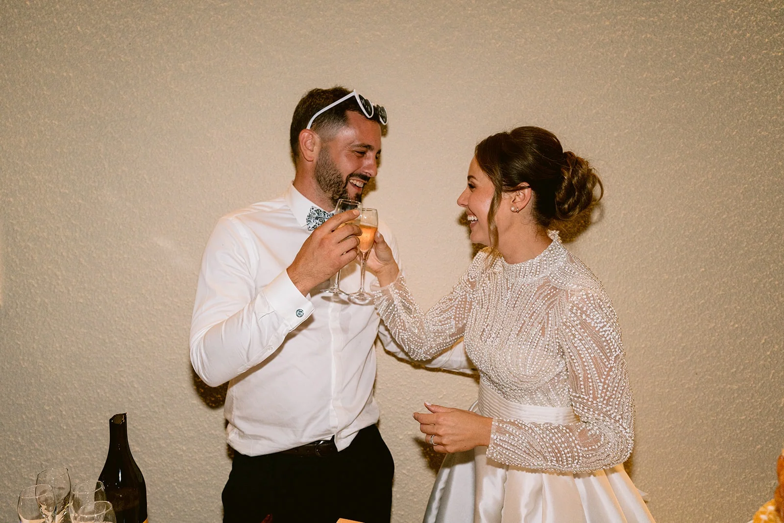 Les mariés trinquent en se regardant, chacun une coupe à la main.