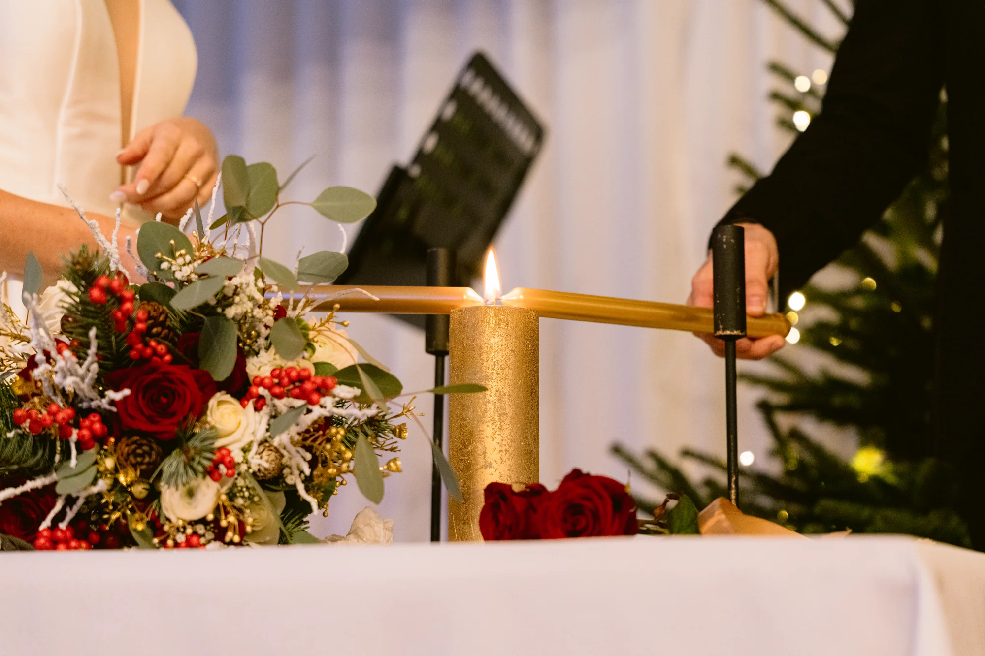 Les mains des mariés autour du sablier de la cérémonie
