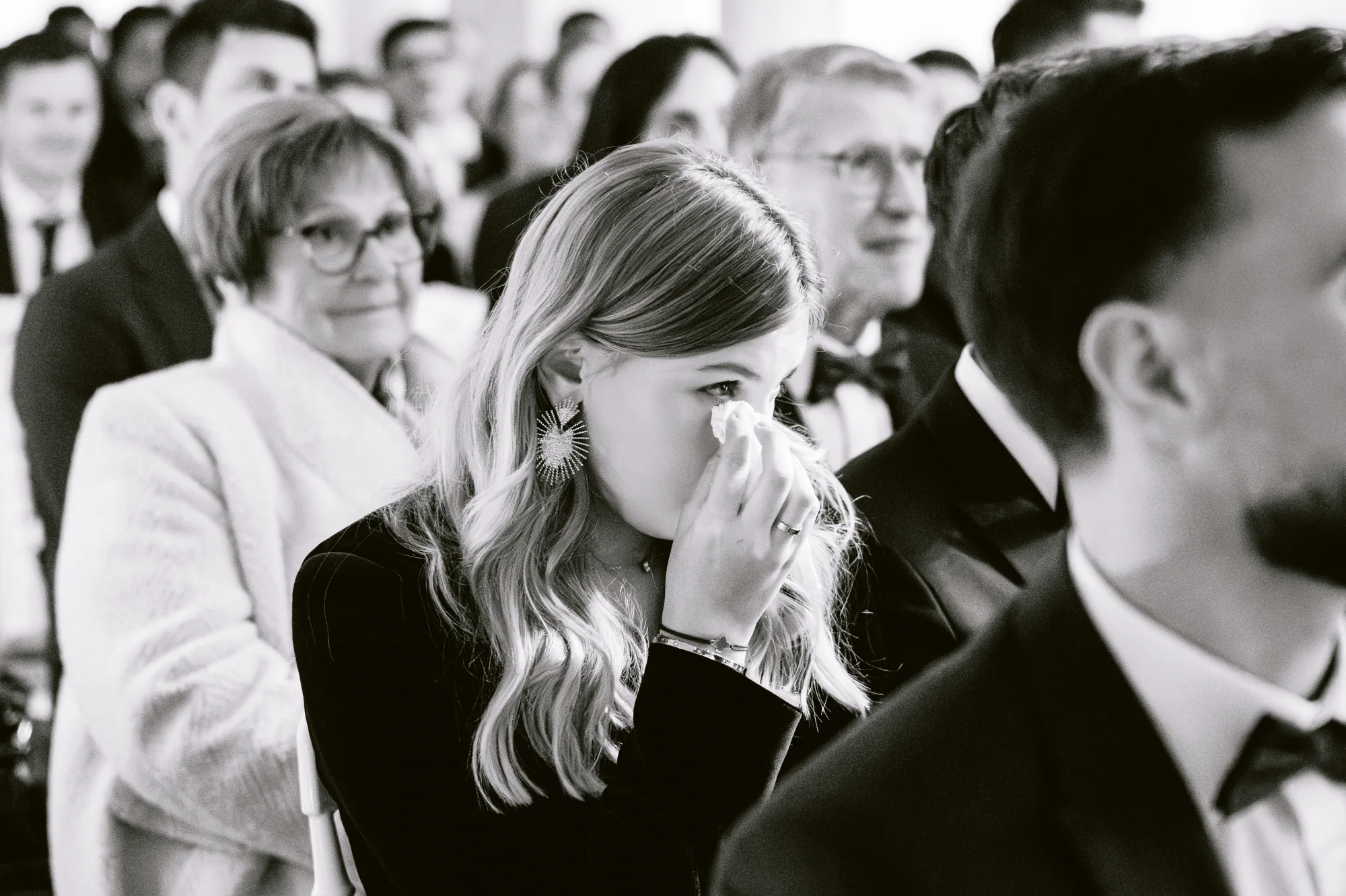 Une invitée émue pendant les discours, en noir et blanc