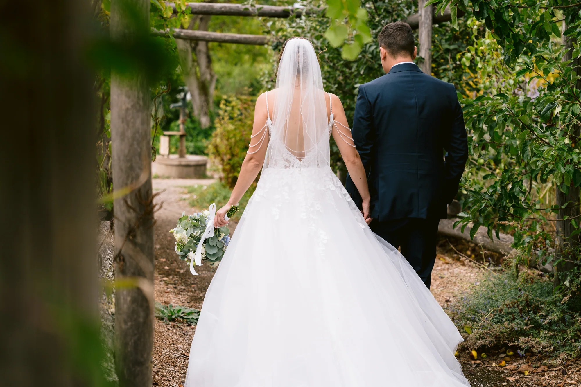 Le couple marche sous une pergola végétale