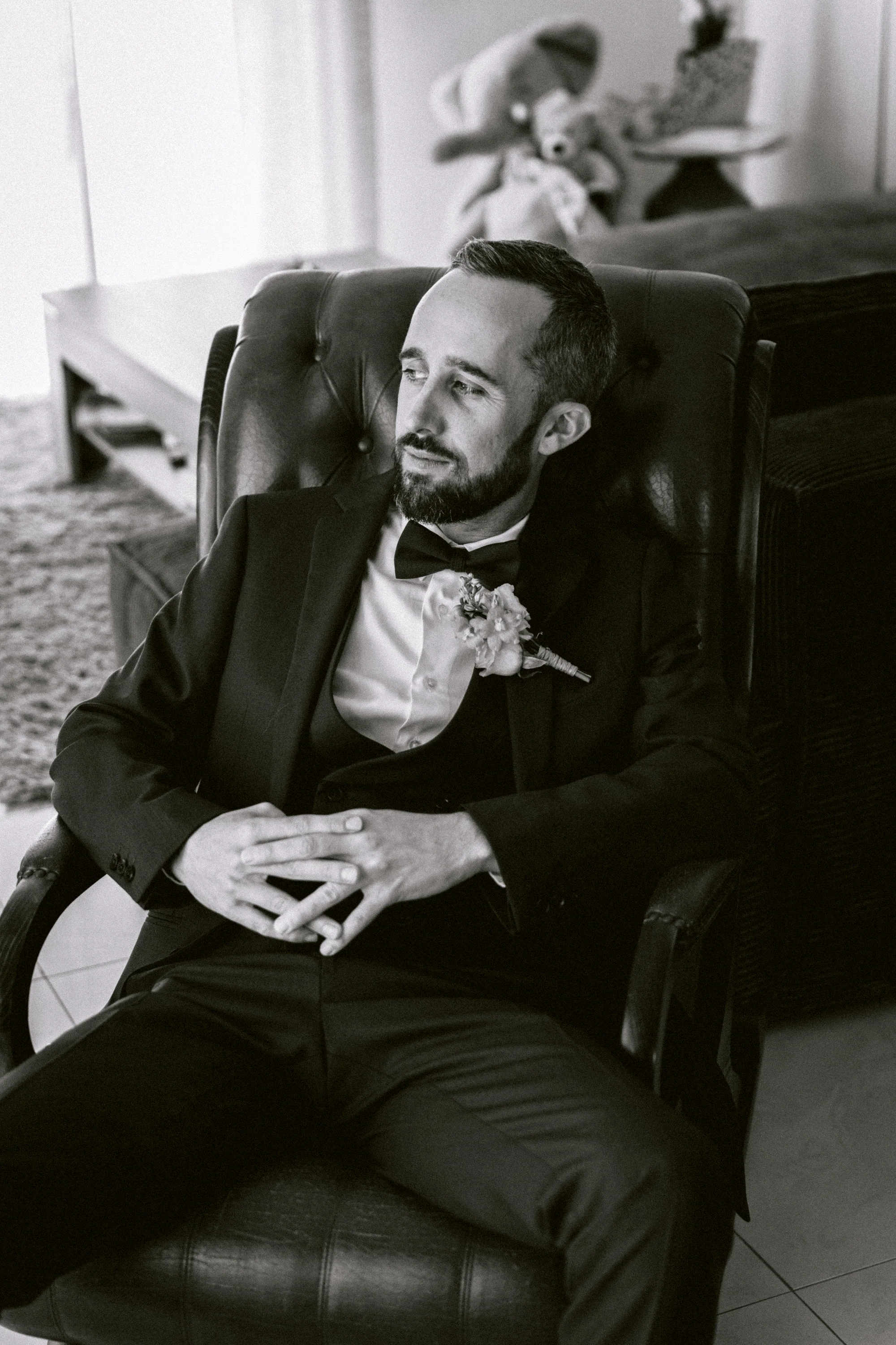 Le marié assis dans un fauteuil, en noir et blanc