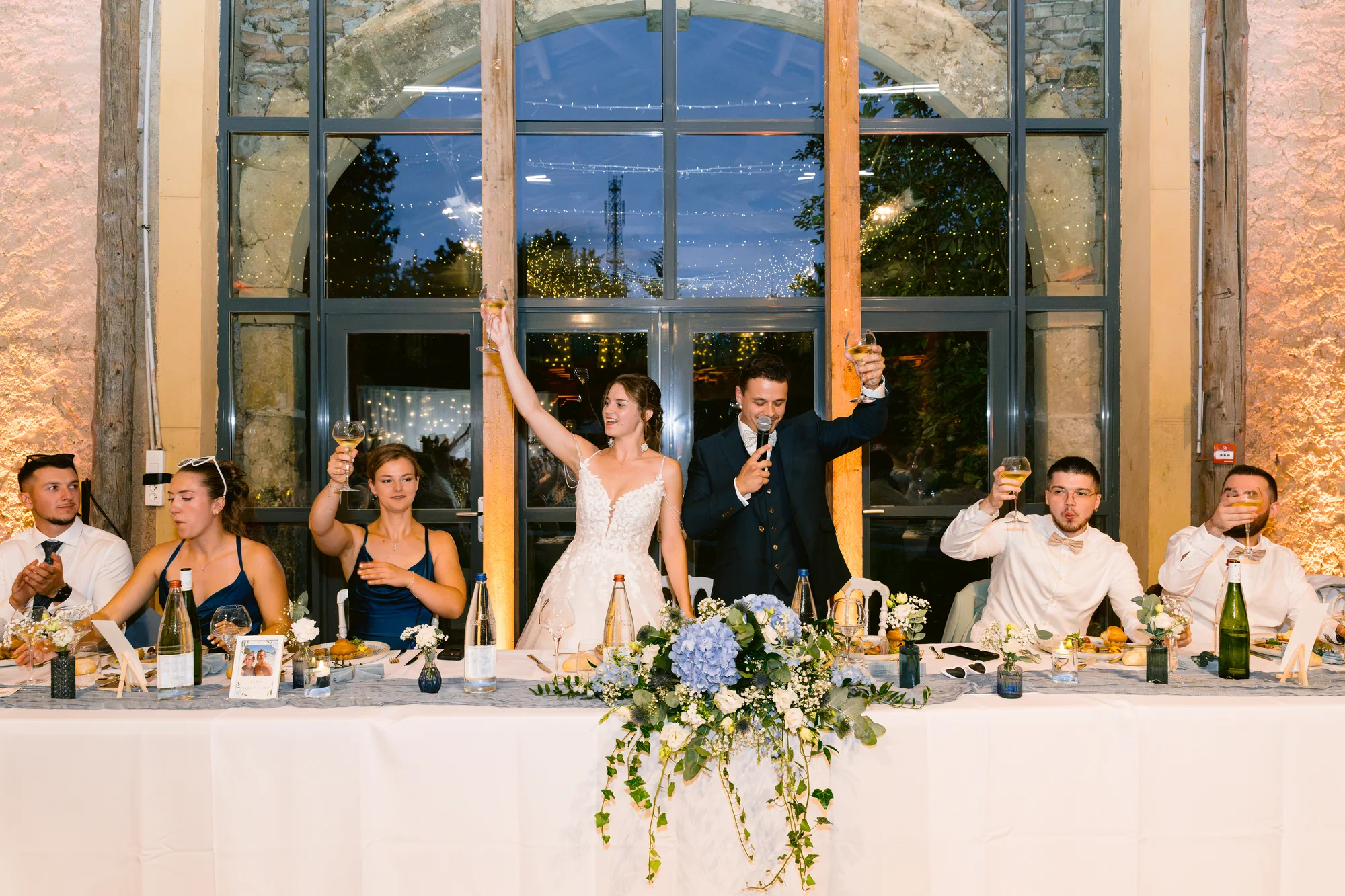 Les mariés lèvent les bras à leur table
